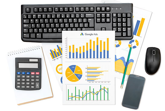 Google ADS dawniej Adwords Google Ads-Bericht mit farbigen Zusatzdiagrammen, Tastatur, Computermaus, Smartphone und Taschenrechner