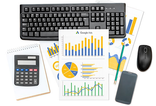 Raport z banerowej wraz z kolorowymi wykresami dodatkowymi, klawiaturą, myszką komputerową, smartfonem i kalkulatorem